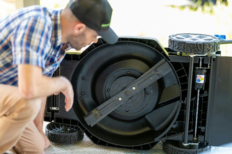 image of man servicing his lawnmower